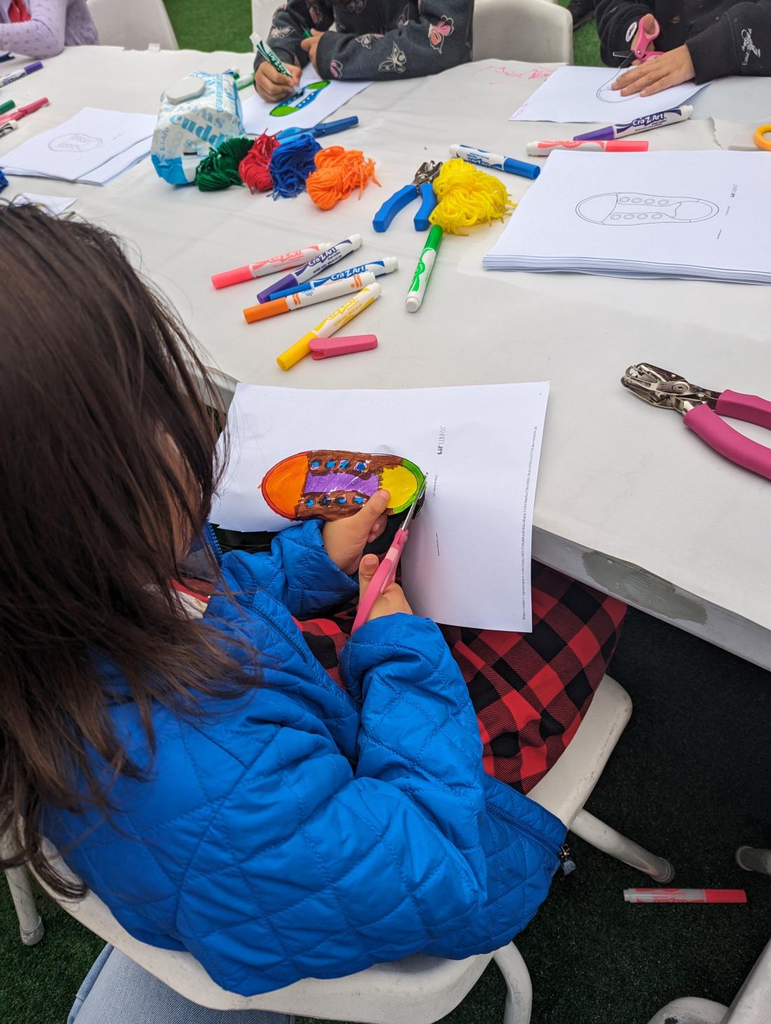 Child cutting a piece of paper for an art activity