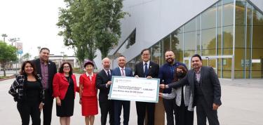 Group of People Holding a Big Check